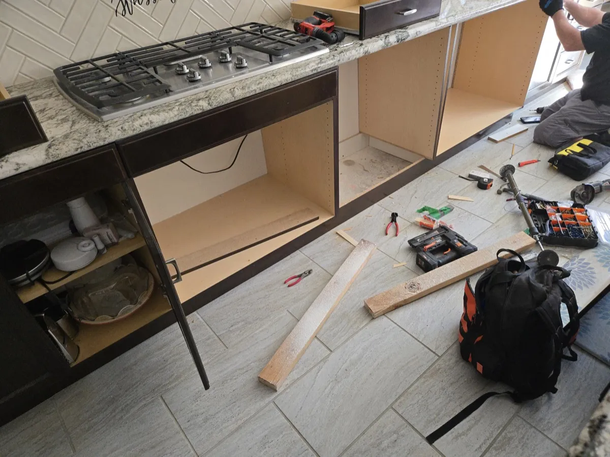 Kitchen cabinet box rebuild in progress with new panels installed and original dark wood faces retained