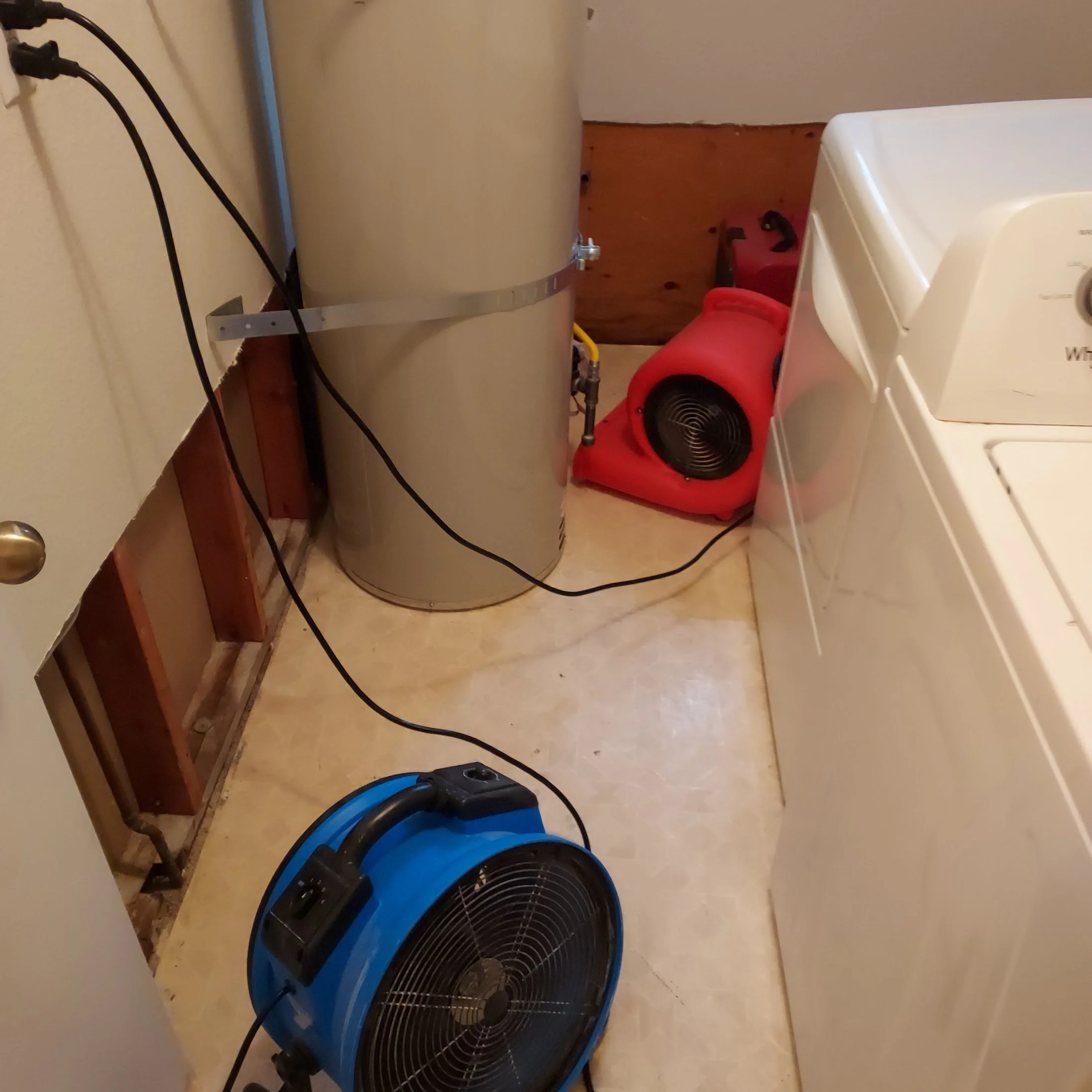 Professional drying fans and dehumidifiers set up in a laundry room